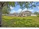 Expansive backyard with green lawn, white fence, and a patio with a pergola at 11616 Thacker Dr, Clermont, FL 34711