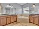 Elegant bathroom featuring double vanities, a soaking tub, and ample counter space at 11616 Thacker Dr, Clermont, FL 34711