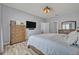 Bright bedroom features a large bed, dresser, mounted TV, and ceiling fan for comfort at 11616 Thacker Dr, Clermont, FL 34711