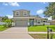 Charming two-story home with a well-manicured lawn, a two-car garage, and a light-blue front door at 11616 Thacker Dr, Clermont, FL 34711
