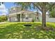 Charming two-story home with a large lawn and mature shade tree with a hanging swing at 11616 Thacker Dr, Clermont, FL 34711
