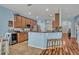 Well-equipped kitchen with breakfast bar, wooden cabinets, and stainless-steel appliances in an open layout at 11616 Thacker Dr, Clermont, FL 34711