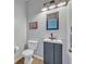 Charming powder room featuring a vanity, toilet, framed mirror, and warm overhead lighting at 11616 Thacker Dr, Clermont, FL 34711