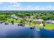 Aerial view of a lakefront home with a screened pool and private boat dock surrounded by lush landscaping at 13626 Sunset Lakes Cir, Winter Garden, FL 34787