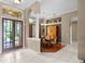 Inviting home foyer leads to the dining room, showcasing hardwood floors and large windows at 13626 Sunset Lakes Cir, Winter Garden, FL 34787