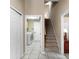 Hallway featuring tiled floors, staircase, laundry room and neutral wall color, providing a clean and bright path at 13626 Sunset Lakes Cir, Winter Garden, FL 34787