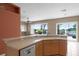 Bright kitchen featuring wood cabinets, granite countertops, and scenic views of the backyard and waterfront at 13626 Sunset Lakes Cir, Winter Garden, FL 34787