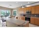 Stylish kitchen featuring wood cabinets, a modern oven, and a breakfast bar overlooking the backyard at 13626 Sunset Lakes Cir, Winter Garden, FL 34787
