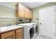 This laundry room features a utility sink, LG washer and dryer, and ample overhead cabinet space at 13626 Sunset Lakes Cir, Winter Garden, FL 34787
