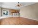 Open-concept living room featuring hardwood floors, a ceiling fan, and a breakfast bar at 13626 Sunset Lakes Cir, Winter Garden, FL 34787