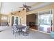 Covered patio with ceiling fans, dining table, chairs, and sliding glass doors to pool and living area at 13626 Sunset Lakes Cir, Winter Garden, FL 34787