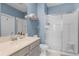 Well-lit bathroom featuring a glass-enclosed shower, single sink vanity and blue accent wall at 1391 Shinnecock Hills Dr, Davenport, FL 33896