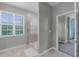 Well-lit bathroom with a glass-enclosed shower and a view to the main bedroom at 1391 Shinnecock Hills Dr, Davenport, FL 33896