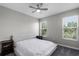 Neutral bedroom with a large bed, two windows with blinds, and two bedside tables at 1391 Shinnecock Hills Dr, Davenport, FL 33896