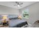Cozy bedroom with a ceiling fan, nightstands with lamps, and a large window at 1391 Shinnecock Hills Dr, Davenport, FL 33896