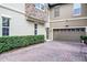 Home exterior with garage, brick driveway and manicured hedges at 1391 Shinnecock Hills Dr, Davenport, FL 33896