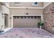Two-car garage of a home with brick driveway and stone facade at 1391 Shinnecock Hills Dr, Davenport, FL 33896