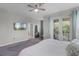 Bright main bedroom with a ceiling fan, TV, balcony, and ensuite bathroom access at 1391 Shinnecock Hills Dr, Davenport, FL 33896