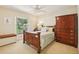 Cozy bedroom with a wooden bed frame, ceiling fan, and a large window overlooking the backyard at 1425 Mt Laurel Dr, Winter Springs, FL 32708