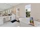 Elegant bathroom with a freestanding tub, vanity, and natural lighting from two windows at 14744 Spotted Sandpiper Blvd, Winter Garden, FL 34787