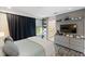 Well-lit bedroom with a TV, gray walls, and built-in shelves with a view of an ensuite bathroom at 14744 Spotted Sandpiper Blvd, Winter Garden, FL 34787