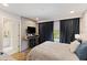 Modern bedroom boasts an ensuite bathroom, a large TV, and a window with black-out curtains at 14744 Spotted Sandpiper Blvd, Winter Garden, FL 34787