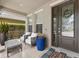 Inviting front porch with comfortable seating, potted plants, and a stylish door with decorative wreath at 14744 Spotted Sandpiper Blvd, Winter Garden, FL 34787