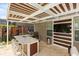 An outdoor kitchen and entertainment area with bar seating and a TV for enjoyment in the backyard at 14744 Spotted Sandpiper Blvd, Winter Garden, FL 34787