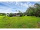 Spacious backyard featuring a screened-in pool, patio, and lush greenery at 15038 Willow Ln, Tavares, FL 32778