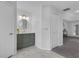 Stylish half-bath with green vanity and modern round mirror at 15038 Willow Ln, Tavares, FL 32778