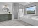 Bright bathroom featuring a soaking tub, separate shower, custom vanity, and stylish gray marble floors at 15038 Willow Ln, Tavares, FL 32778