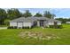 Charming single-story home with a well-manicured lawn, mature landscaping, and a light gray exterior at 15038 Willow Ln, Tavares, FL 32778