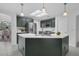 An open kitchen design features a large island with sink, dark green cabinets, and stainless steel appliances at 15038 Willow Ln, Tavares, FL 32778