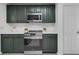 This kitchen features stainless steel appliances, stone countertops, and dark green cabinets at 15038 Willow Ln, Tavares, FL 32778