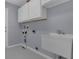 Laundry room featuring a utility sink, washer hookup, overhead cabinets, and gray walls at 15038 Willow Ln, Tavares, FL 32778