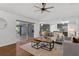 Open-concept living room with hardwood floors, modern decor, and sliding glass doors to the outdoor patio at 15038 Willow Ln, Tavares, FL 32778