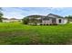 Screened-in pool area with lush landscaping and view of the grassy backyard at 15038 Willow Ln, Tavares, FL 32778