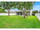 Expansive backyard with lush green grass, mature trees, and a screened lanai for outdoor living at 1706 Terra Cota Ct, Orlando, FL 32825