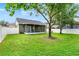Backyard showing the lawn, mature trees, and screened-in porch at 1706 Terra Cota Ct, Orlando, FL 32825