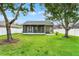 Backyard showing the lawn, mature trees, and screened-in porch at 1706 Terra Cota Ct, Orlando, FL 32825