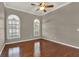 Bedroom featuring hardwood floors and arched windows, with a ceiling fan overhead at 1706 Terra Cota Ct, Orlando, FL 32825