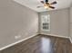 Cozy bedroom with ceiling fan, a window with blinds, and beautiful wood-look flooring at 1706 Terra Cota Ct, Orlando, FL 32825