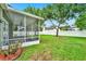 View of the screened lanai overlooking the spacious, tree-lined backyard and a white fence at 1706 Terra Cota Ct, Orlando, FL 32825