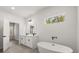 Modern bathroom featuring dual vanity, soaking tub, and natural light from window at 17465 Sw 41St Cir, Ocala, FL 34473