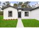 A close up of the home's front door, complemented by a green lawn and minimal landscaping at 17465 Sw 41St Cir, Ocala, FL 34473