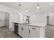 Open kitchen featuring a large island with a sink, dishwasher, and sleek white cabinetry at 17465 Sw 41St Cir, Ocala, FL 34473