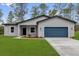 Charming single-story home with a blue garage door and freshly manicured front lawn at 17501 Sw 41St Cir, Ocala, FL 34473