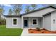 Close up of the entrance of the single story home with neat landscaping and a blue front door at 17501 Sw 41St Cir, Ocala, FL 34473