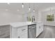 Bright kitchen featuring white cabinets, stainless steel appliances, and a large island with a quartz countertop at 17501 Sw 41St Cir, Ocala, FL 34473