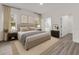 Staged main bedroom with wood-look flooring, natural light and ensuite bathroom at 17501 Sw 41St Cir, Ocala, FL 34473